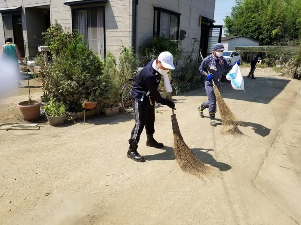 道路一面に広がった砂や土を掃き集め（岡山市東区）