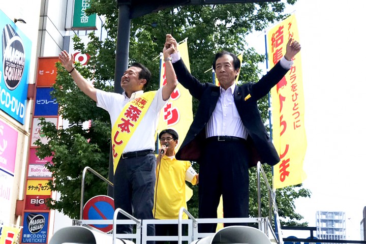 しっかりつないだ手を掲げる平野幹事長と森本候補