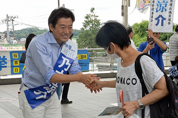 握手で有権者に支持を訴える乃木候補